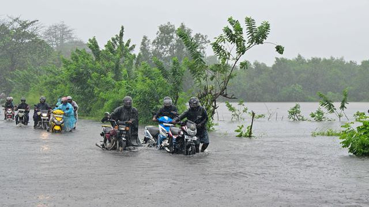 Departemen Meteorologi memperingatkan badai tersebut dapat menguat saat bergerak melintasi pulau itu dalam 12 jam ke depan. Tampak dalam foto, para pengendara berjalan di jalanan yang terenda