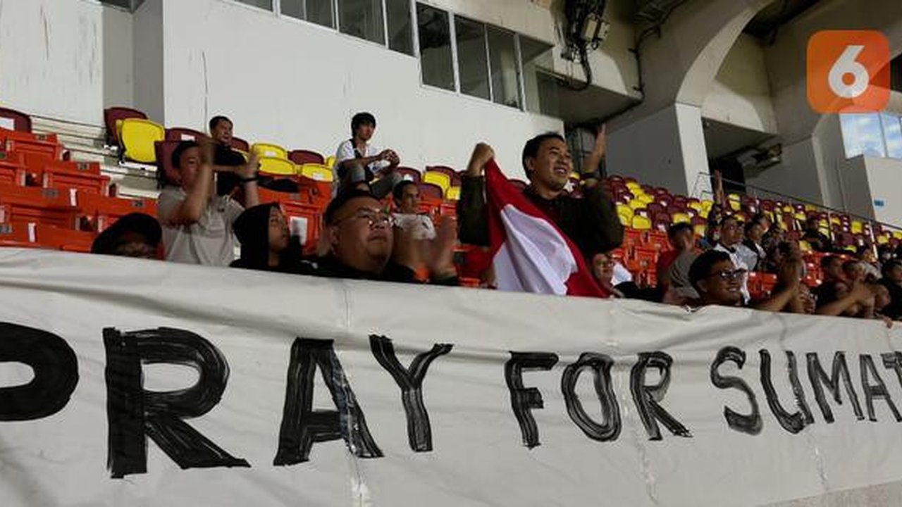 Sejumlah suporter Timnas Indonesia U-22 membentangkan spanduk PRAY FOR SUMETERA saat menonton SEA Games 2025 cabang olahraga sepak bola melawan Filipina U-22 di 700th Anniversary of Chiang Ma