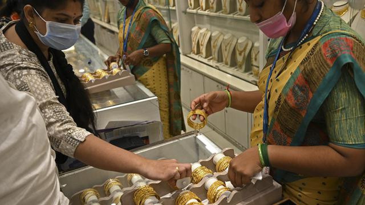 Seorang pelanggan (kiri) memeriksa gelang emas selama festival Hindu 'Akshaya Tritiya', hari keberuntungan dalam kalender Hindu untuk membeli barang-barang berharga, di ruang pamer perhias