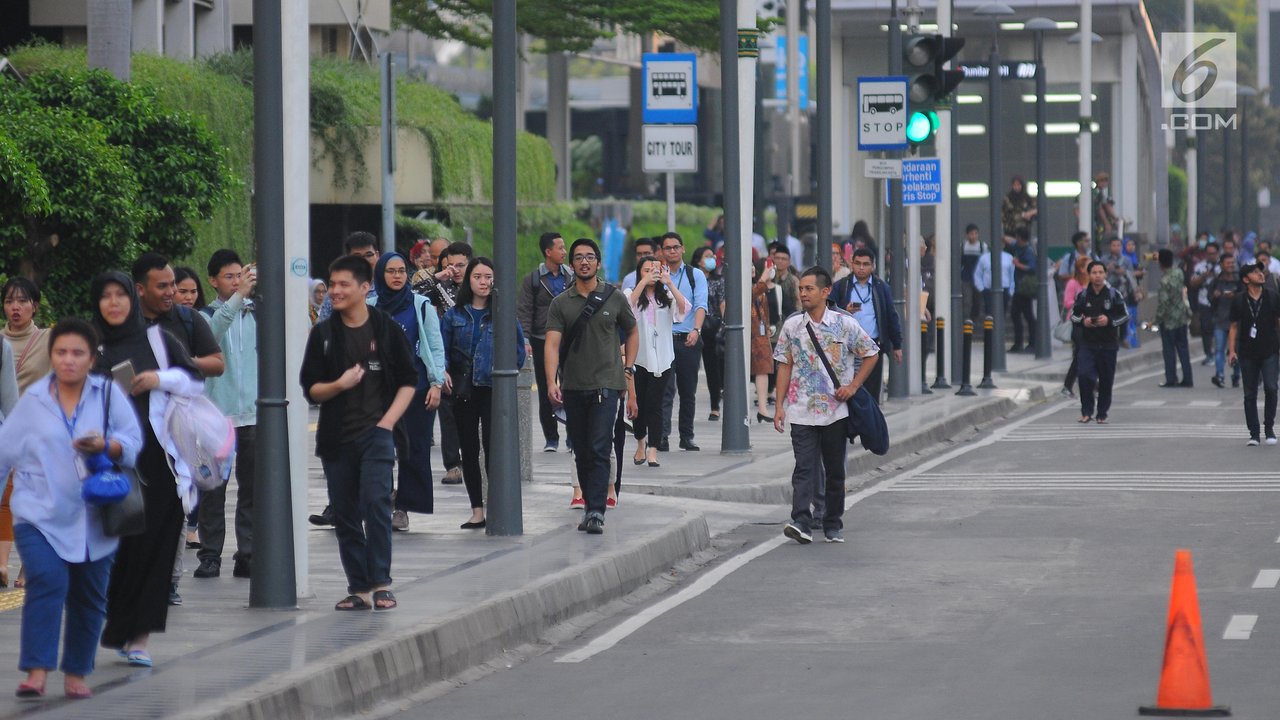 Sejumlah karyawan terpaksa berjalan kaki usai pulang kerja di kawasan Thamrin, Jakarta, Selasa (21/5). Akibat adanya aksi masa tolak hasil pemilu 2019 membuat sejumlah ruas jalan di kawasan tersebut di tutup. (Liputan6.com/Angga Yuniar)