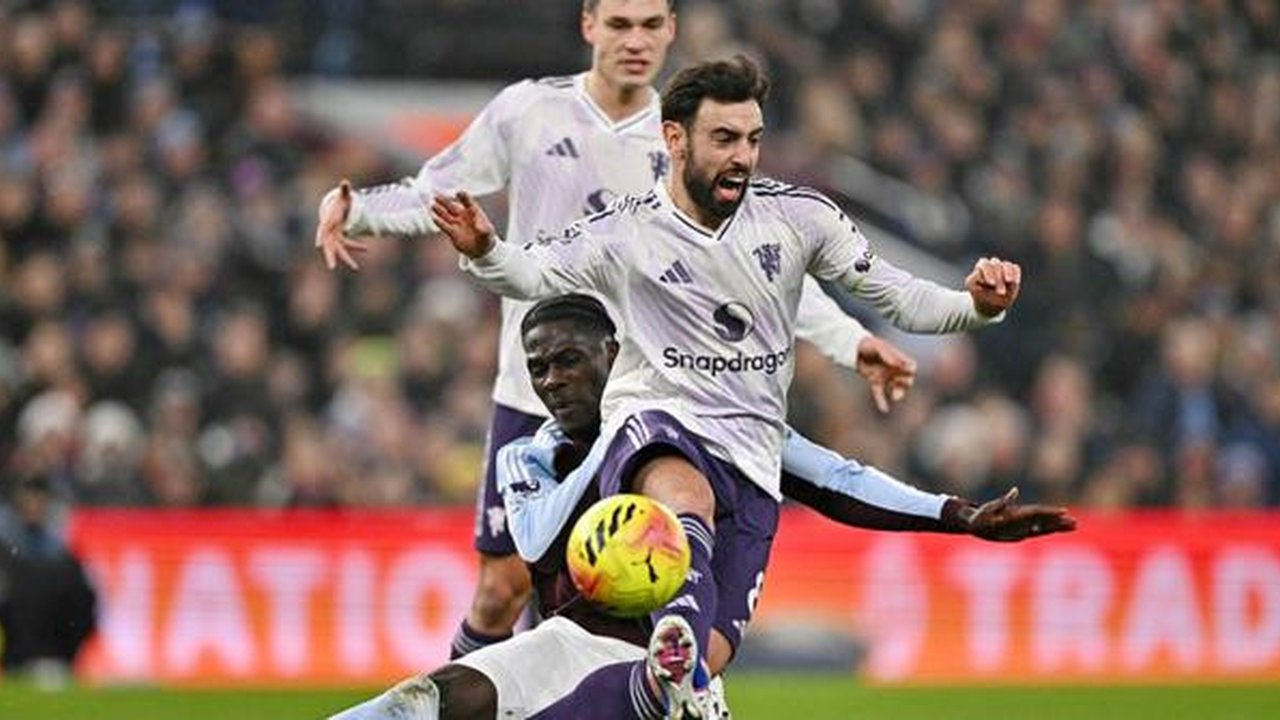 Gelandang Manchester United, Bruno Fernandes, dibekap cedera saat timnya kalah 1-2 dari Aston Villa pada laga pekan ke-17 Premier League di Villa Park, Minggu (21/12/2025) malam WIB. (AFP/Ben