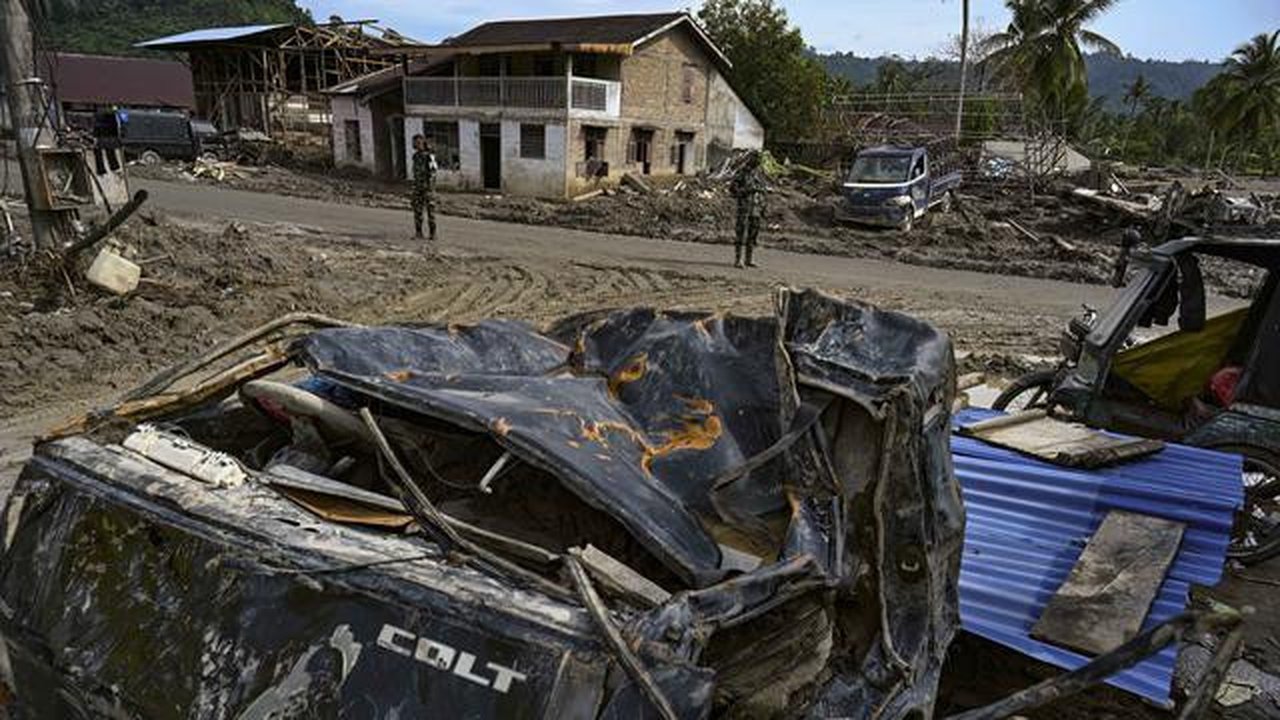 Dua personel Tentara Nasional Indonesia (TNI) membantu pemulihan lingkungan di kawasan permukiman yang terdampak banjir bandang di Desa Aek Garoga, Tapanuli Selatan, Sumatera Utara, pada Sabt