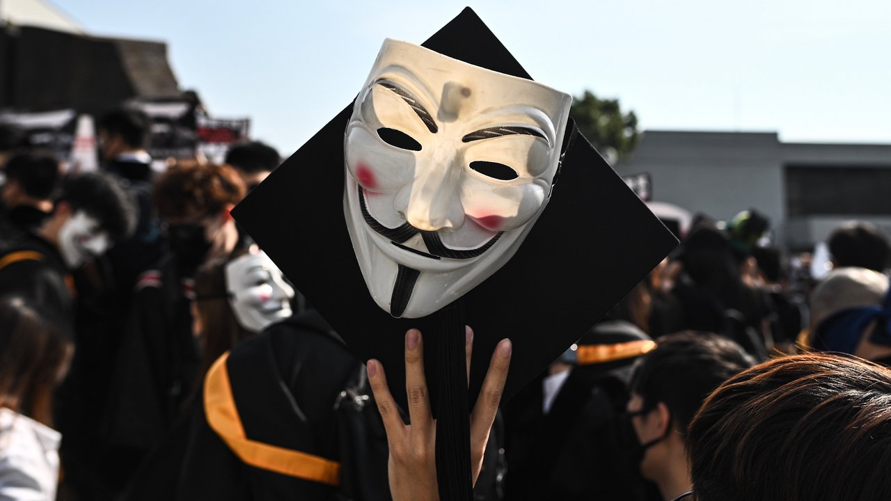 Mahasiswa mengenakan topeng Guy Fawkes selama aksi protes pada upacara kelulusan mereka di Chinese University of Hong Kong, Hong Kong, Kamis (7/11/2019). Sekitar seribu mahasiswa mengabaikan larangan mengenakan topeng yang dikeluarkan pemerintah pada Oktober 2019. (Philip FONG / AFP)