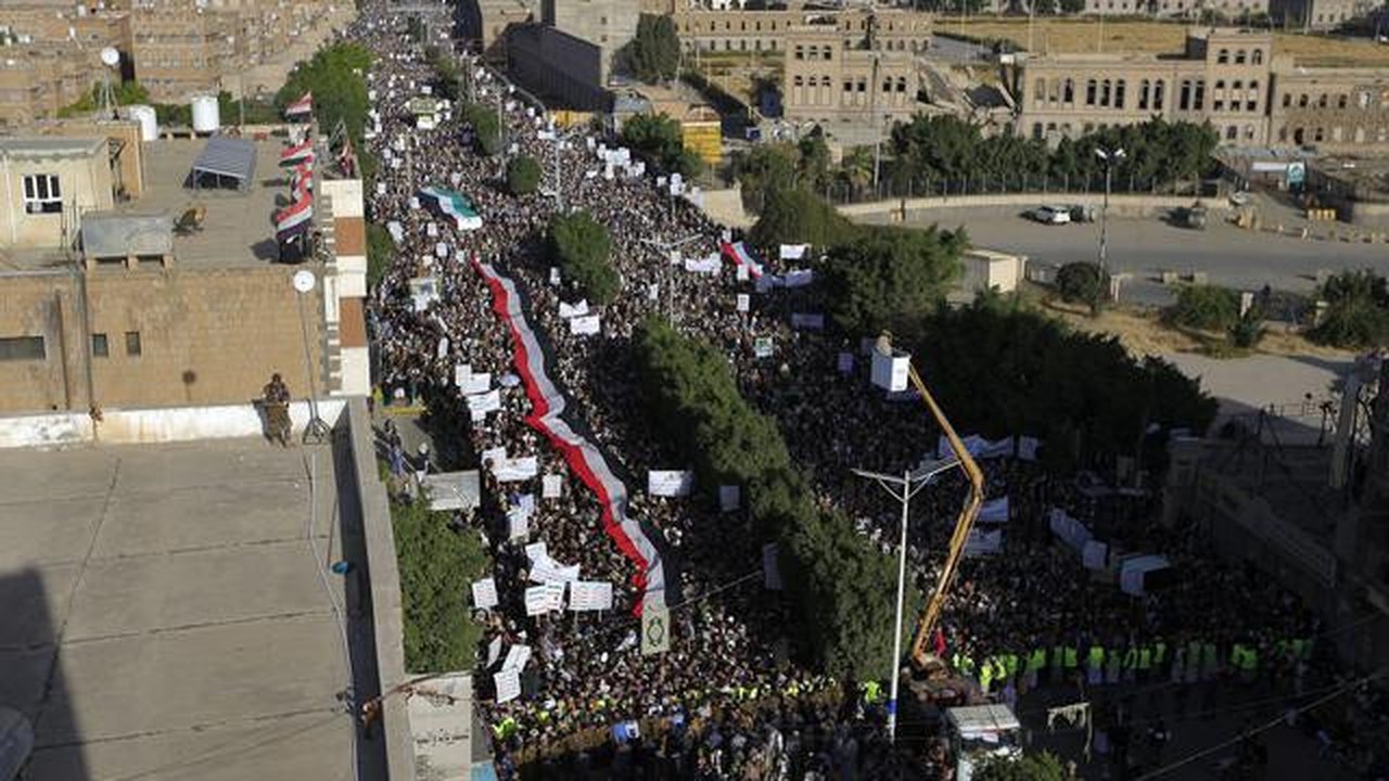Bendera Yaman dibentangkan saat demonstrasi mengecam pembakaran Al-Quran oleh seorang politisi Swedia di ibu kota Sanaa pada 23 Januari 2023. Ribuan warga Yaman di ibu kota Sanaa turut berunj
