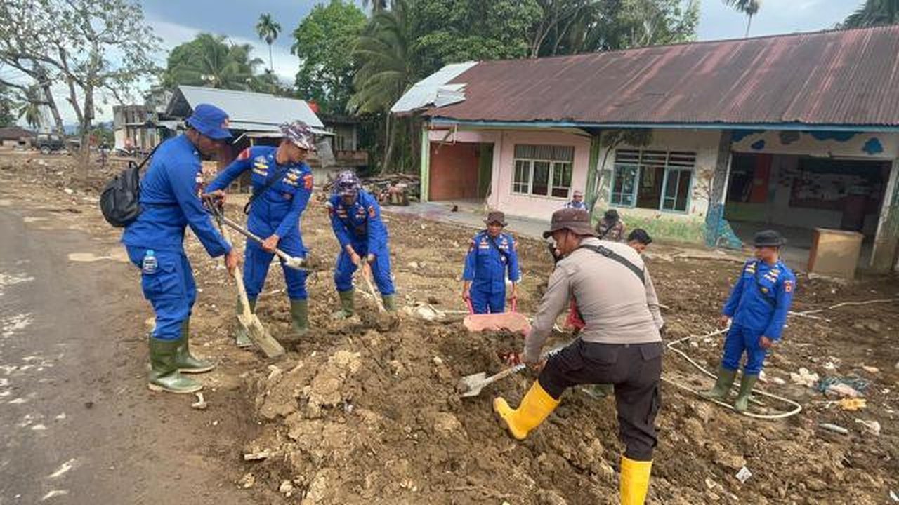 Para personel Brimob dikerahkan membersihkan lumpur, sampah, dan sisa material banjir. (foto: Istimewa)