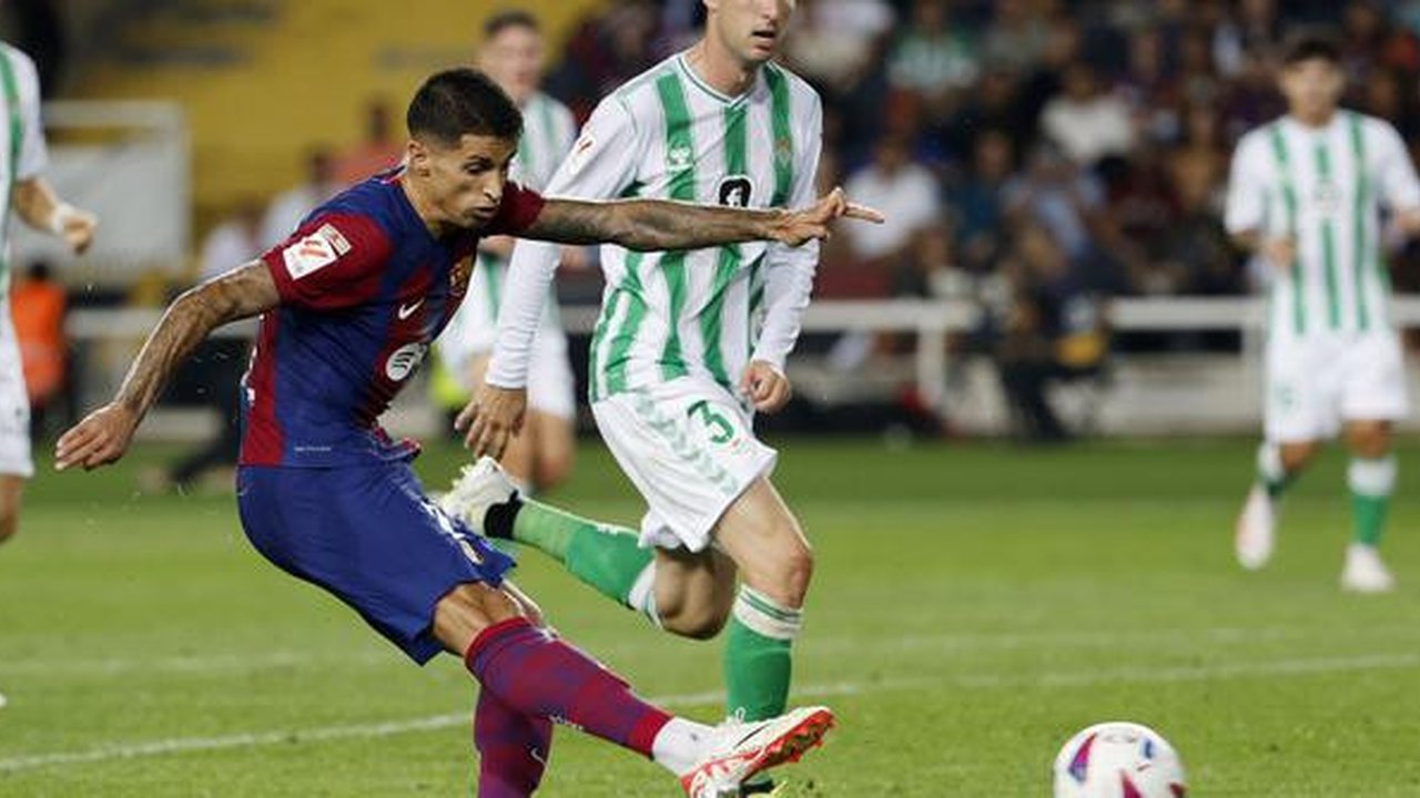 Pemain Barcelona, Joao Cancelo, mencetak gol ke gawang Real Betis pada laga Liga Spanyol di Estadi Olimpic Lluis Companys, Minggu (17/9/2023). Barca menang dengan skor 5-0. (AP Photo/Joan Mon