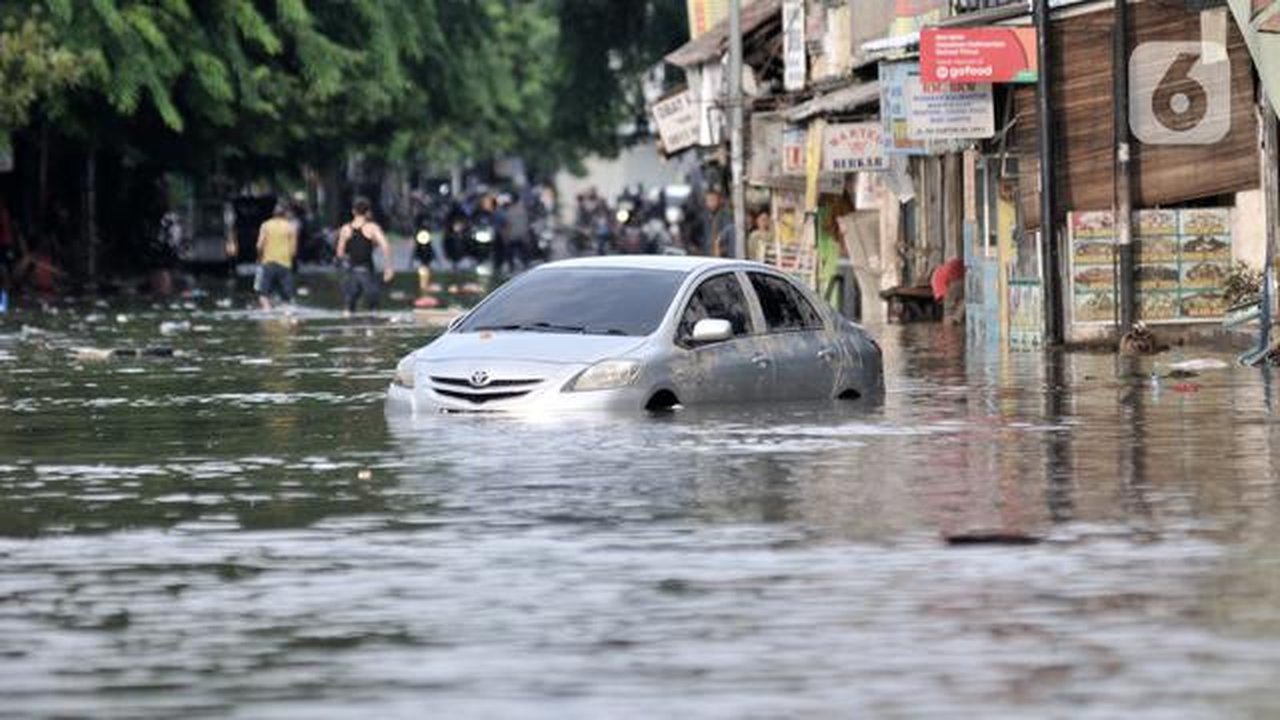 Sebuah mobil terjebak banjir di Jalan RA Kartini, Bekasi, Jawa Barat, Kamis (2/1/2020). Banjir yang merendam Jalan RA Kartini sejak kemarin melumpuhkan akses kendaraan dan perekonomian warga