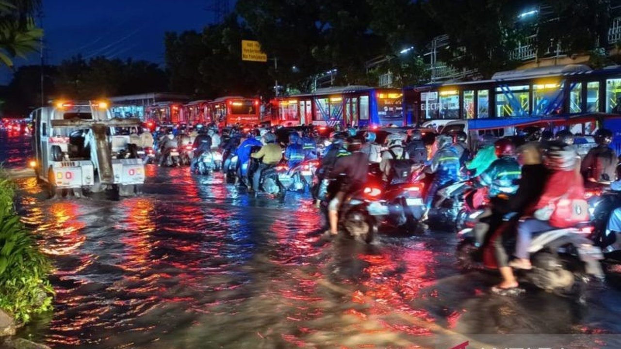 Banjir Jakarta dengan ketinggian air mencapai 10-20 sentimeter di Jalan DI Panjaitan, Jakarta Timur, menyebabkan kemacetan lalu lintas yang parah dan keluhan dari para pengendara pada Kamis malam.