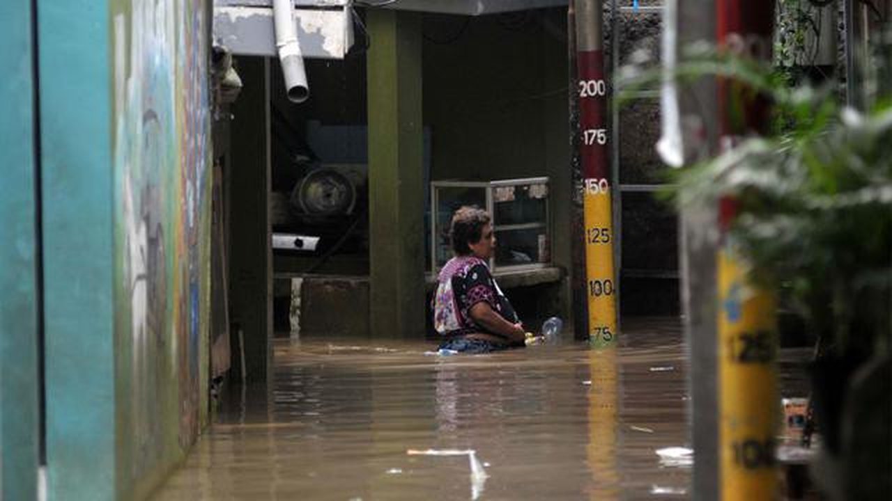 Aktivitas warga Kebon Pala, Kampung Melayu Jakarta Timur di tengah banjir akibat luapan kali Ciliwung, Selasa (2/7/2024). (merdeka.om/Imam Buhori)