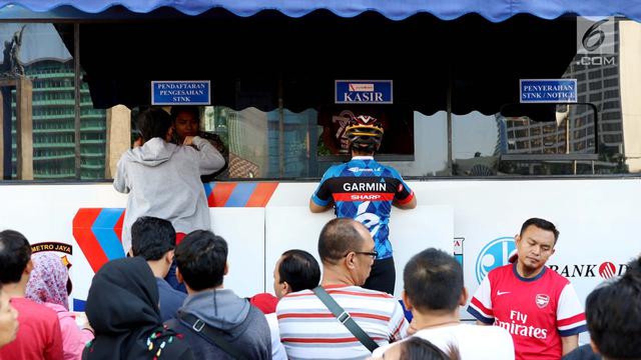 Warga membayar pajak kendaraan bermotor di samsat keliling di car free day, Jakarta, Minggu (27/8). Layanan pembayaran pajak Surat Tanda Nomor Kendaraan (STNK) bisa dilakukan tanpa membawa sa