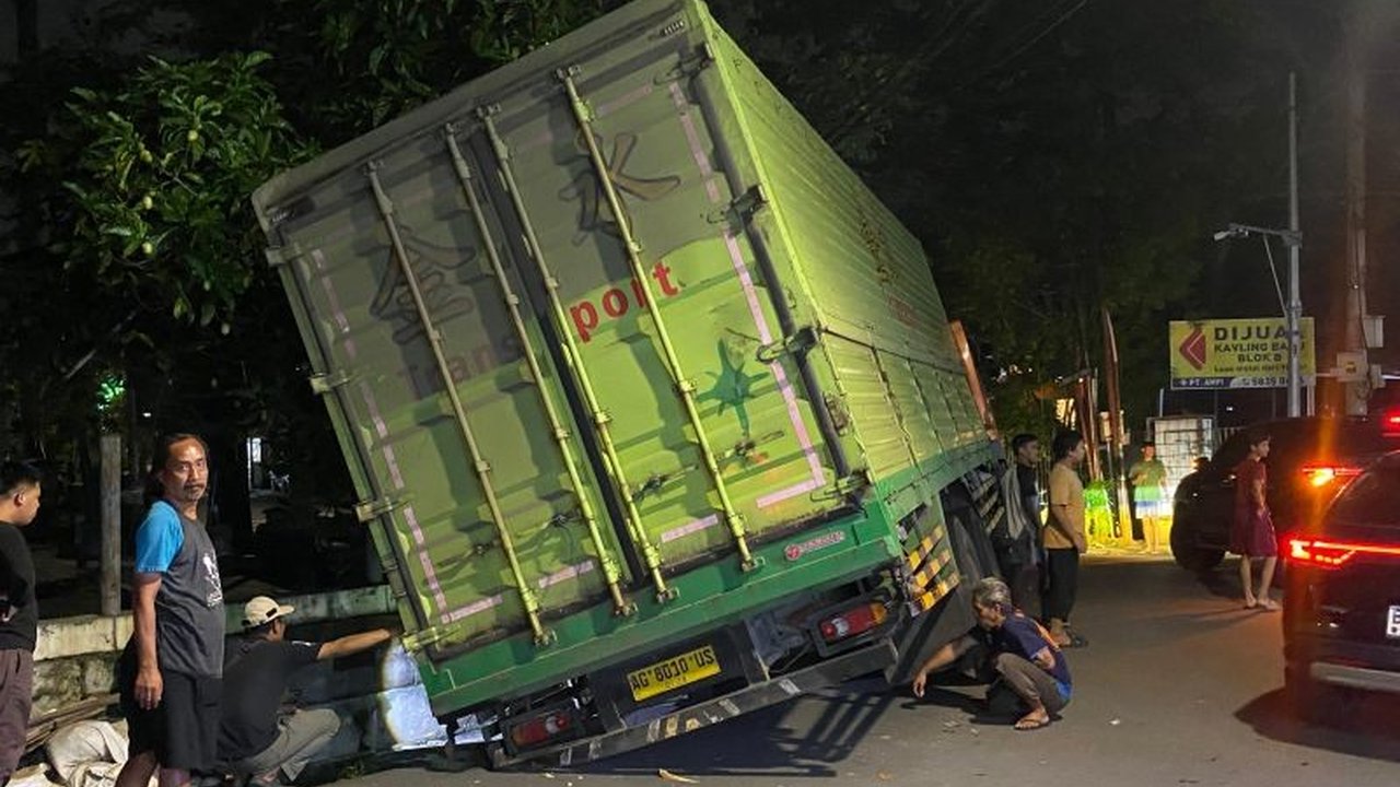 Upaya evakuasi truk bermuatan 37 ton yang terperosok di selokan Puri Kembangan, Jakarta Barat, masih terkendala hingga tengah malam, menyebabkan kemacetan parah di lokasi.