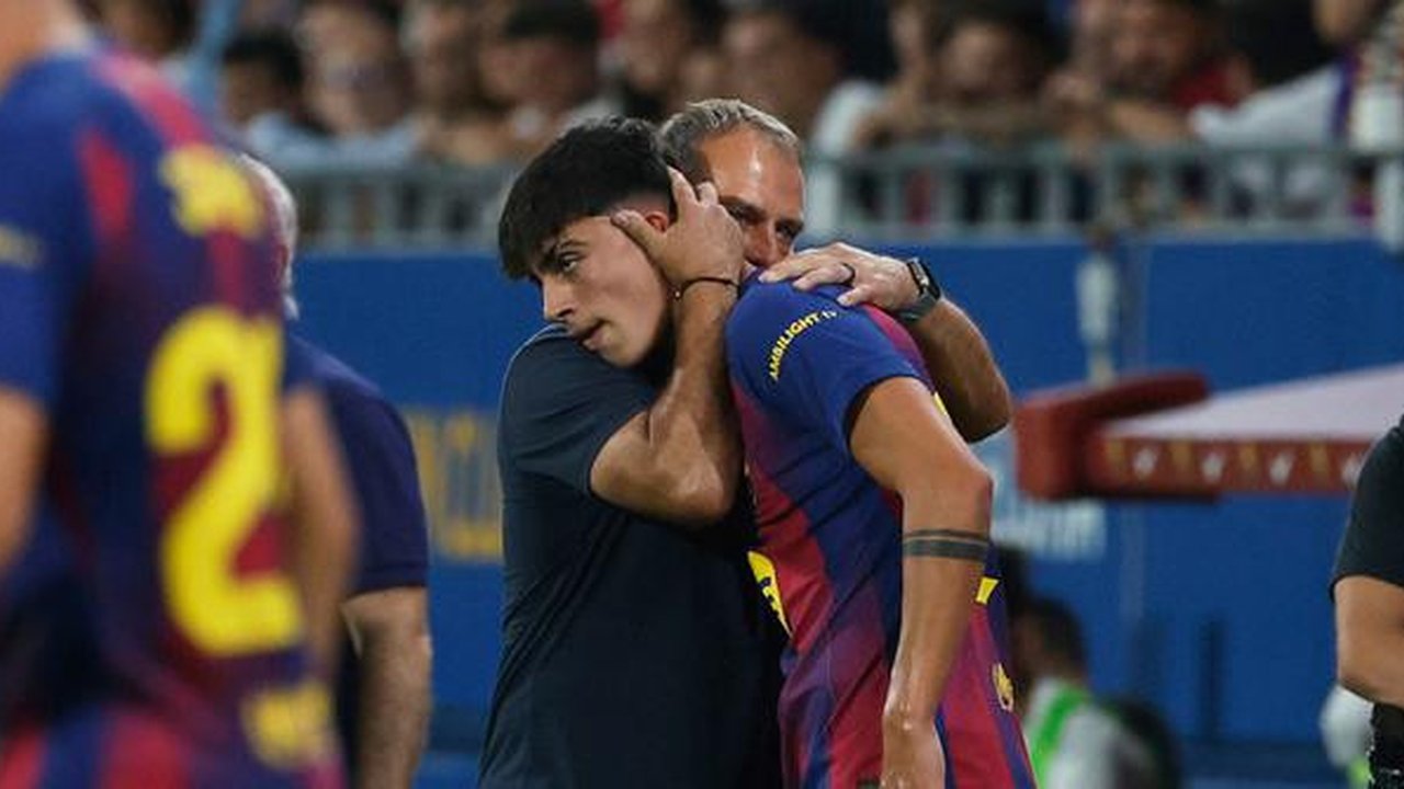 Marc Bernal mendapat pelukan hangat dari Hansi Flick di laga La Liga 2025/2026 antara Barcelona vs Valencia, Senin (15/9/2025). (AP Photo/Joan Monfort)