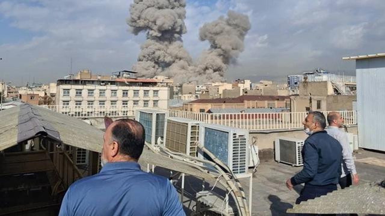Orang-orang menyaksikan kepulan asap membubung di langit Teheran, Iran, setelah terjadinya ledakan, Sabtu (28/2/2026) akibat serangan Israel dan Amerika Serikat. (Dok. AP)