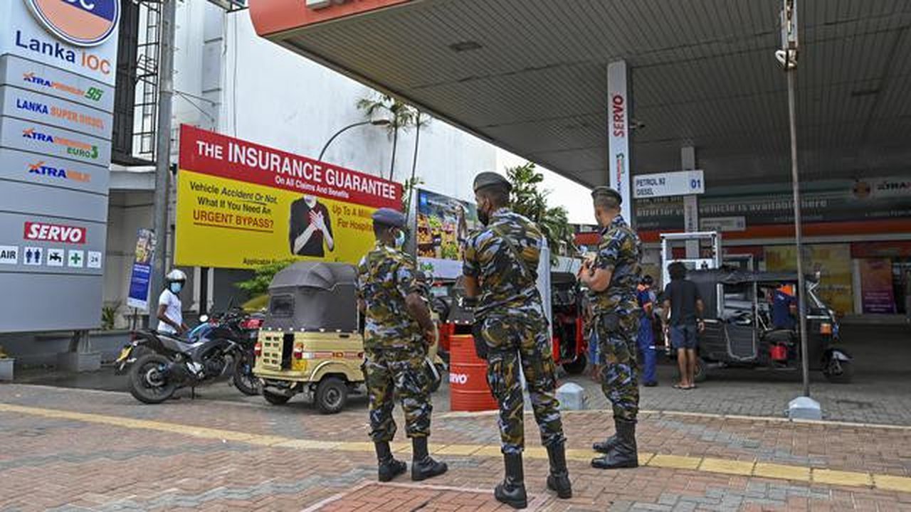 Tentara berjaga saat pengendara antre untuk membeli bahan bakar di stasiun bahan bakar Lanka IOC di Kolombo, Selasa (24/5/2022). Sri Lanka yang kekurangan uang menaikkan harga bahan bakar sec