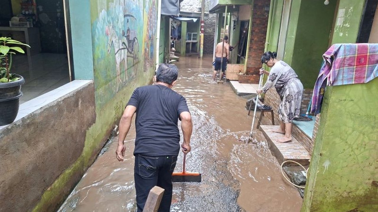 Setelah Banjir Kebon Pala surut hingga 25 cm, warga di Kampung Melayu, Jakarta Timur, mulai bergotong royong membersihkan sisa lumpur dan material yang mengotori rumah mereka.