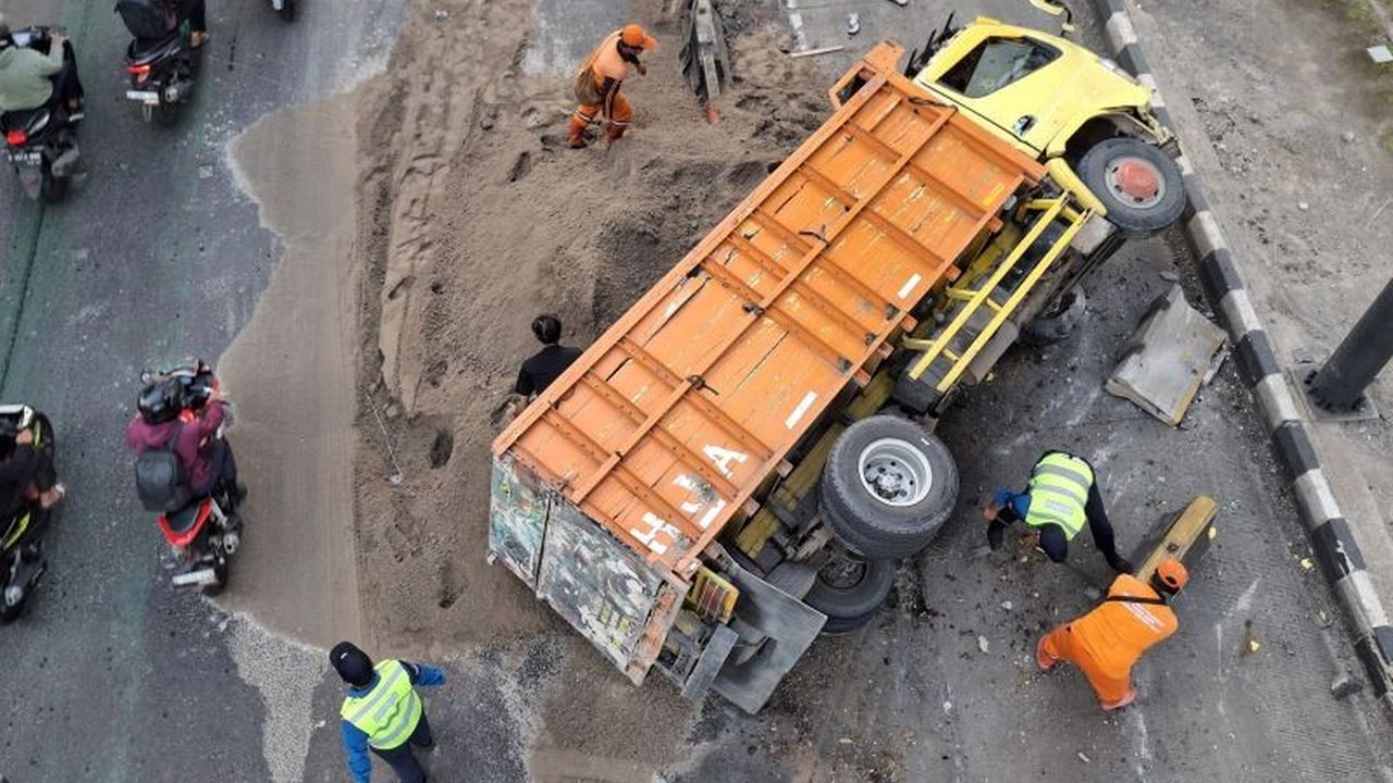 Sebuah truk bermuatan pasir terguling di Tebet, Jakarta Selatan, pada Sabtu pagi akibat sopir mengantuk. Kecelakaan truk terguling ini memicu kemacetan dan kerugian materiil.