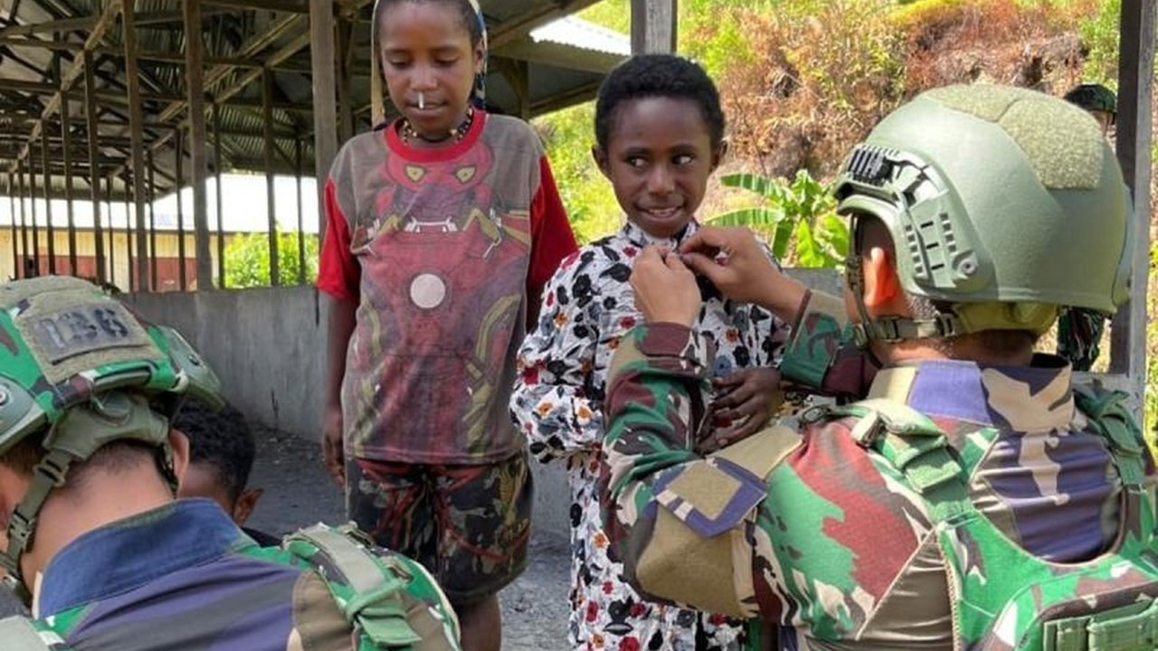 Satgas Yonif 136/TS Pererat Komunikasi Sosial dengan Pembagian Pakaian Layak di Tingginambut