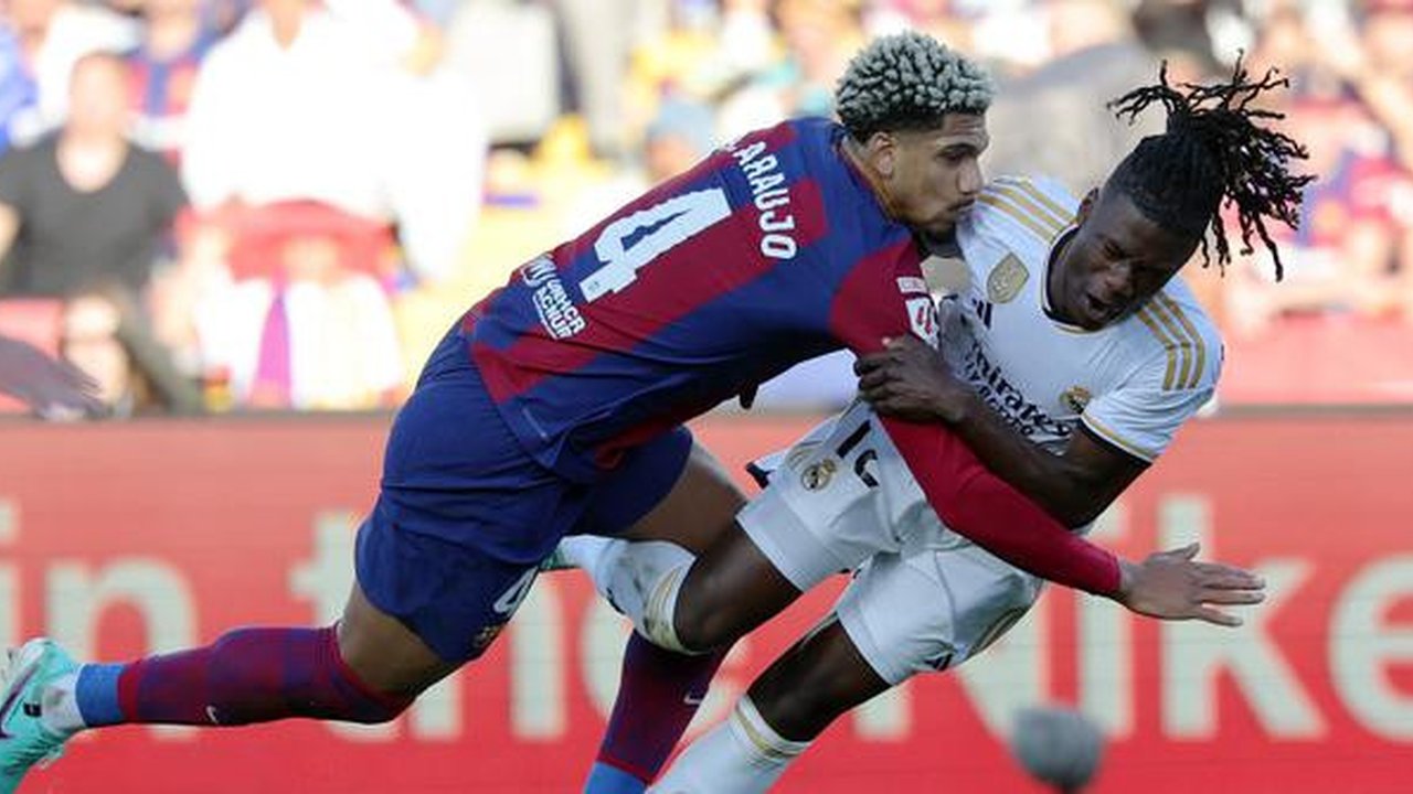 Bek Barcelona, Ronald Araujo melanggara gelandang Real Madrid, Eduardo Camavinga dalam laga El Clasico di La Liga 2023/2024. (AFP/Lluis Gene)