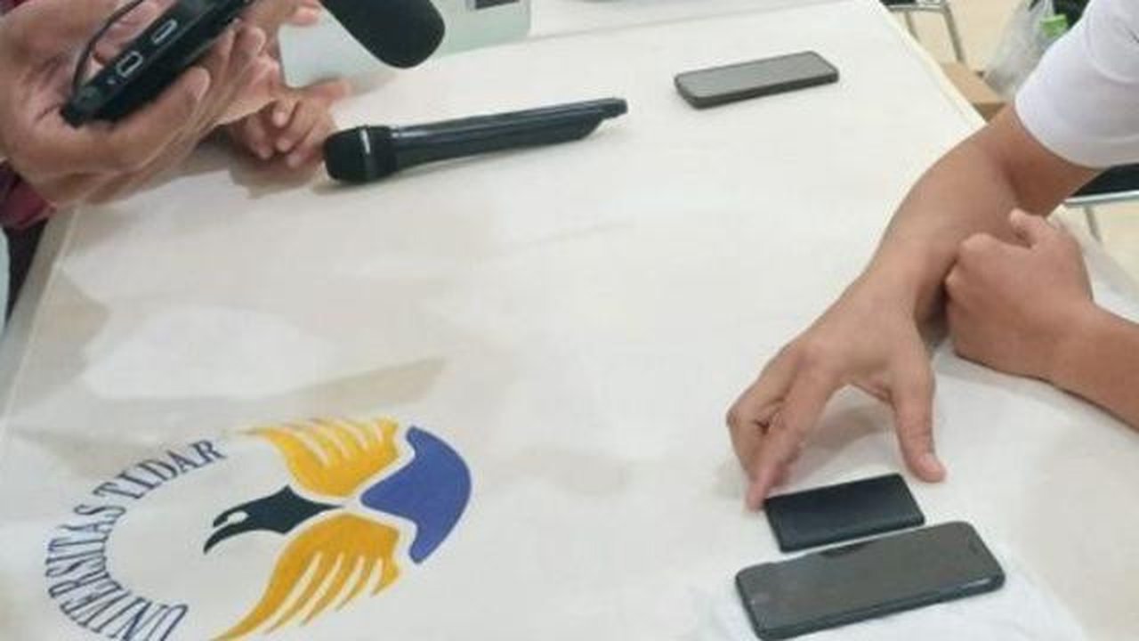 Barang bukti perangkat tambahan berupa telepon seluler serta sebuah kotak elektronik berbentuk chip yang disamarkan menggunakan sampul menyerupai kartu akses hotel sebagai bentuk kamuflase. (