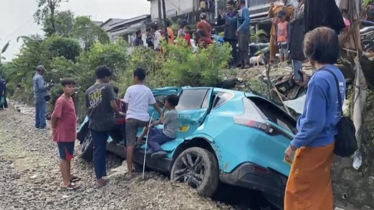 Taksi Green SM yang tertemper oleh KRL di perlintasan sebidang di jalan Ampera, Kota Bekasi, jadi tontonan warga sekitar. (Foto: Liputan6.com/Rifqy Alief Abiyya).