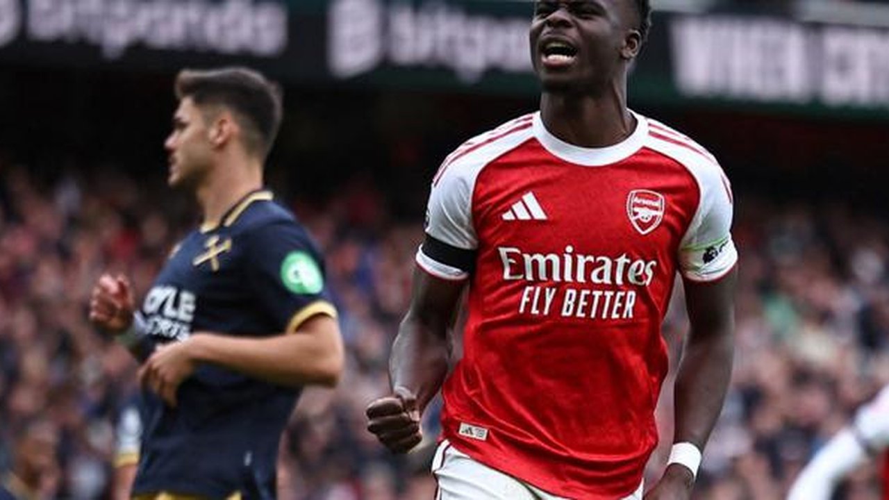 Gelandang Arsenal asal Inggris #07, Bukayo Saka, merayakan gol kedua tim dari titik penalti dalam pertandingan Premier League antara Arsenal dan West Ham United di Stadion Emirates, London