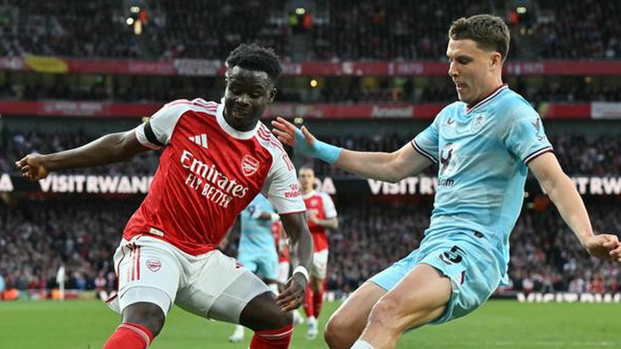 Bukayo Saka mencoba menggocek pemain Burnley. (Glyn KIRK / AFP)