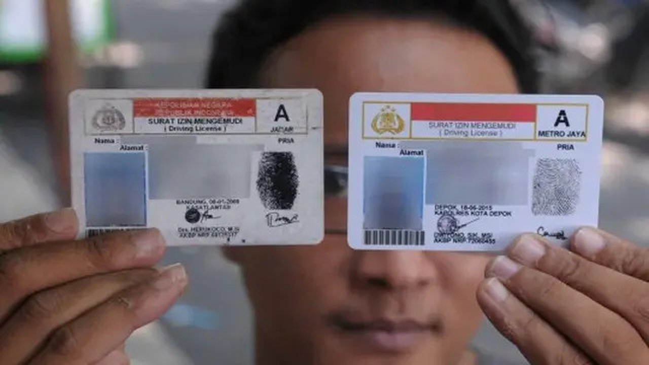 Warga menunjukkan SIM lama dan yang baru saja diperpanjang melalui layanan online di area Car Free Day, Bundaran HI, Jakarta, Minggu (27/9). 2015 merdeka.com/imam buhori