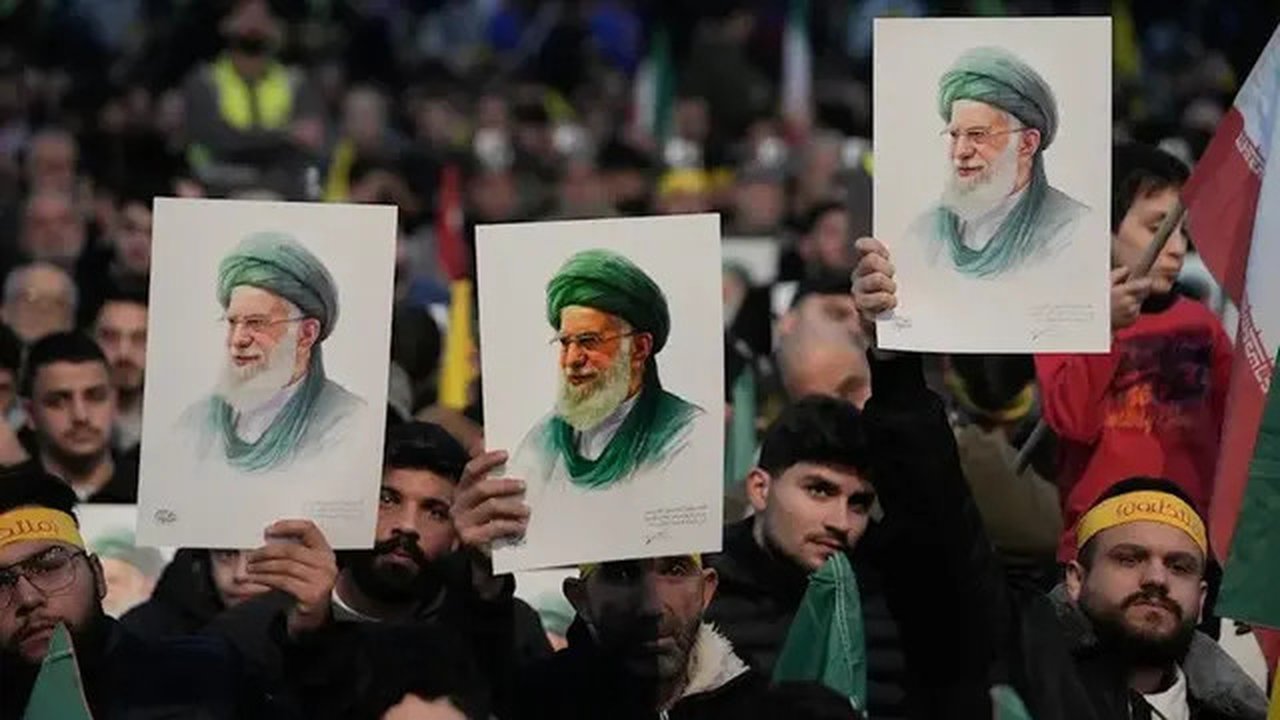 Para pendukung Hizbullah mengangkat potret Pemimpin Tertinggi Iran Sayyed Ali Khamenei dalam sebuah aksi unjuk rasa untuk menunjukkan solidaritas mereka terhadap Iran, di kawasan pinggiran se