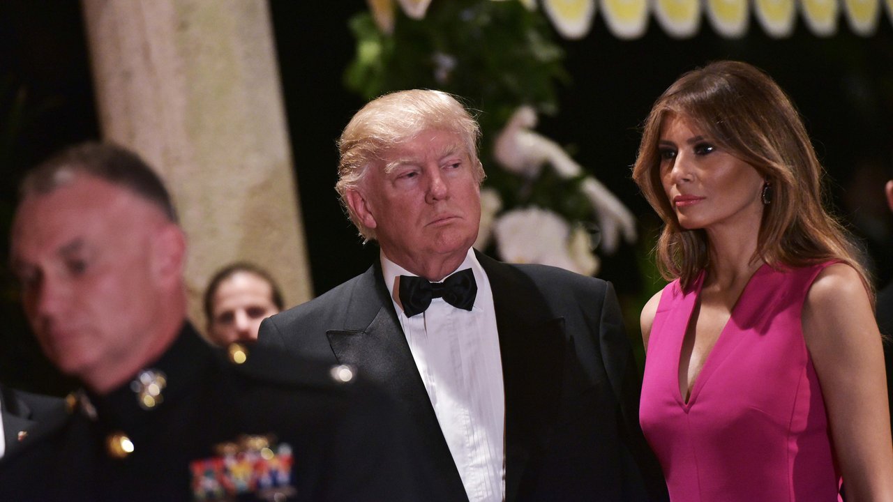 Melania Trump mendampingi Donald Trump saat menghadiri gala tahunan Palang Merah Amerika ke-60 di Mar-a-Lago, Florida, AS (4/2). First Lady Melania Trump tampil anggun dengan mengenakan gaun berwarna merah muda. (AFP/Mandel Ngan)