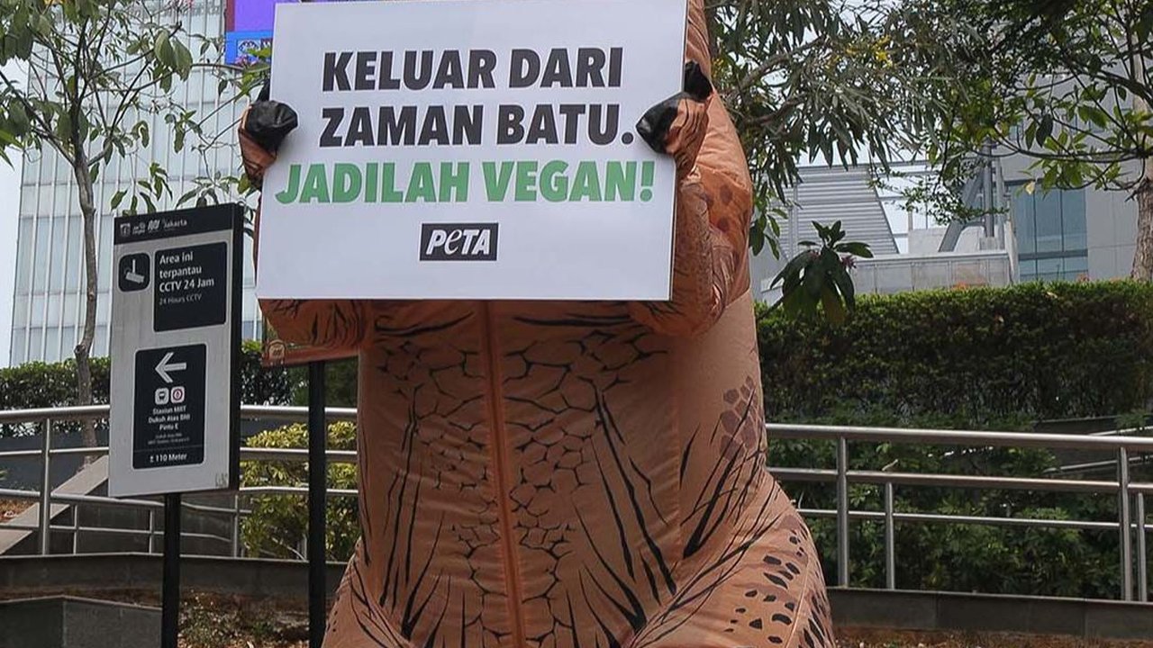 FOTO: Berkostum Dinosaurus, Aktivis PETA Ajak Masyarakat Hidup Vegan Tanpa Eksploitasi Hewan
