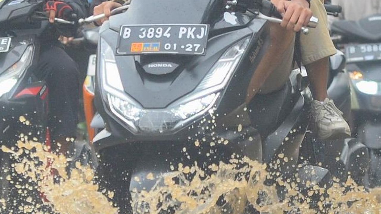 FOTO: Luapan Air Kali Baru di Depan Pasar Induk Kramat Jati Banjiri Jalan Raya Bogor, Lalu Lintas Macet Parah