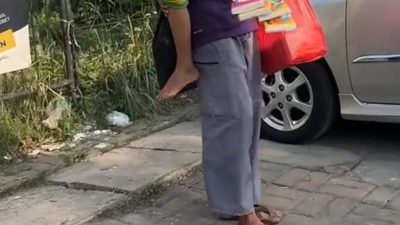 Kisah Haru Pak Alam, Penjual Tisu Keliling yang Jualan Sambil Gendong Anaknya