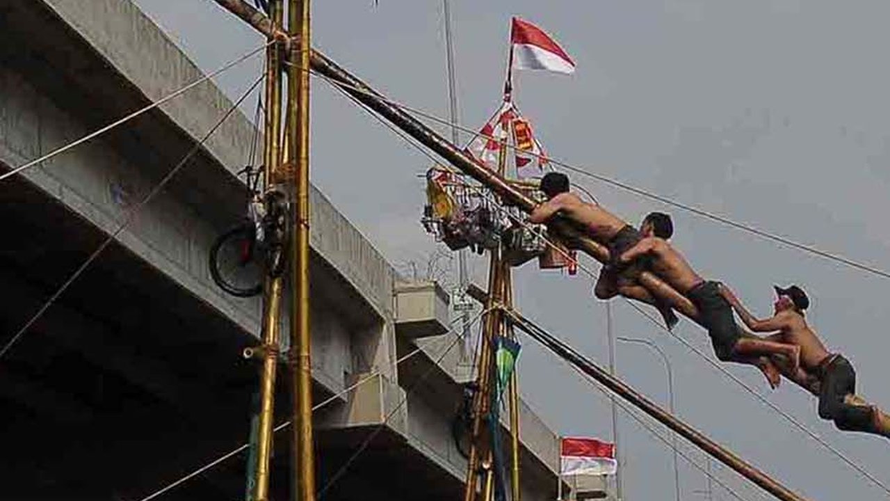 FOTO: Serunya Lomba Panjat Pinang Berhadiah Emas di Aliran Kalimalang, Gagal Jaga Keseimbangan Auto Nyebur