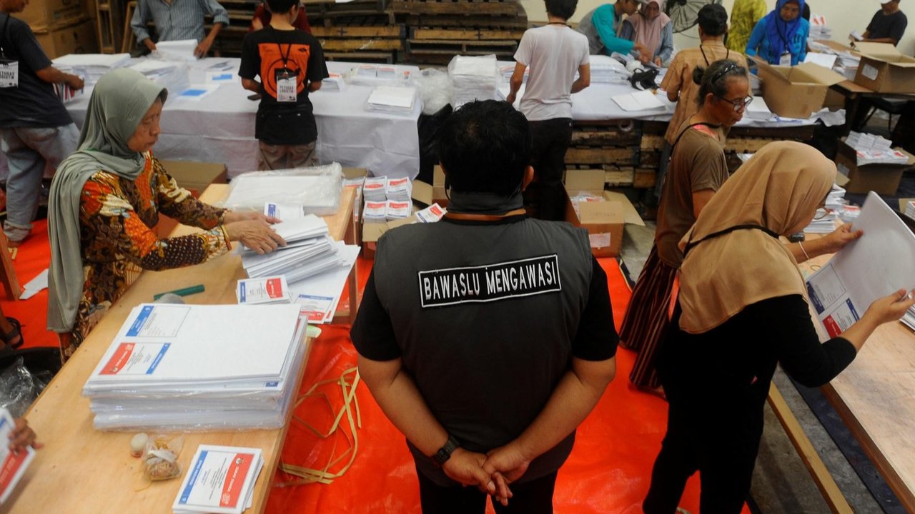 Anggota Polresta Tangerang Selatan berjaga saat sejumlah pekerja melipat surat suara di gudang logistik KPU Kota Tangerang Selatan, Banten, Rabu (27/12/2023). Untuk tahap awal Kantor KPU setempat melipat kertas suara DPRD .