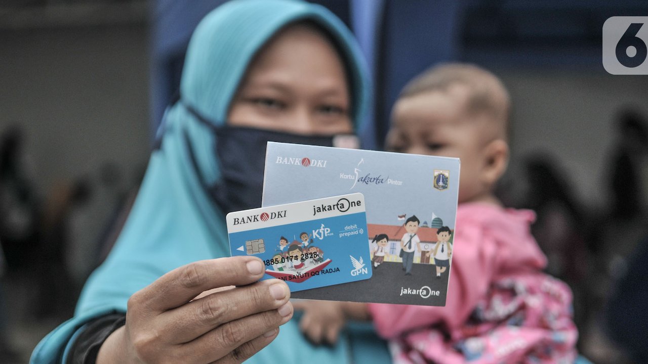 Orangtua dari anak penerima saat menunjukkan KJP yang baru diterima di kawasan Matraman, Jakarta, Selasa (24/11/2020). Penyaluran KJP plus tahap kedua ini menggunakan data baru berdasarkan pembaruan berkas warga penerima yang rampung pada bulan Oktober lalu. (merdeka.com/Iqbal S. Nugroho)