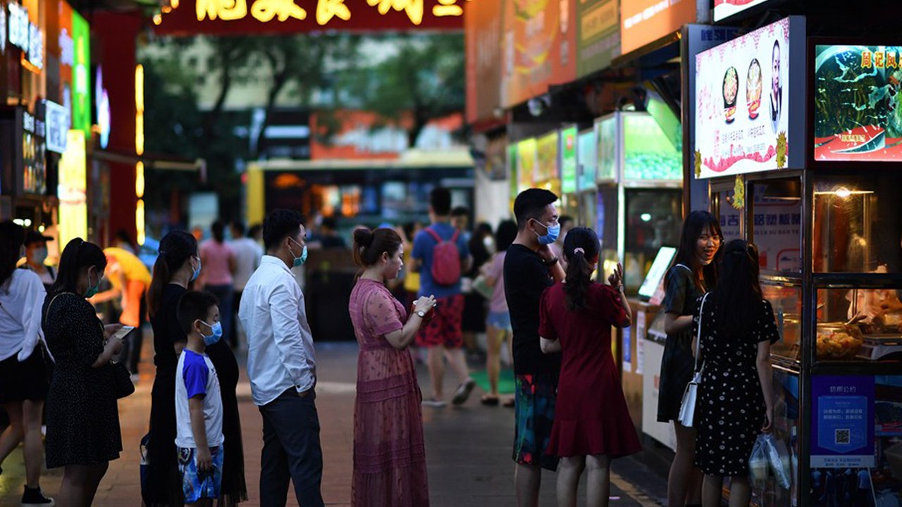 Warga mengantre untuk membeli makanan di pedagang kaki lima di Haikou, ibu kota Provinsi Hainan, China selatan (26/3/2020). Provinsi Kepulauan Hainan di China selatan pada Selasa (24/3) mencatatkan penurunan jumlah kasus penyakit coronavirus baru (COVID-19) yang ada menjadi nol. (Xinhua/Guo Cheng)
