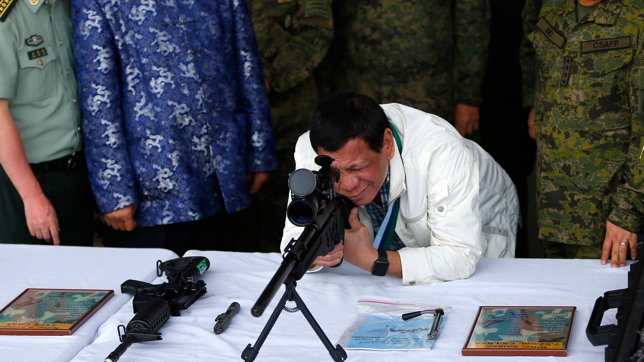 Presiden Filipina Rodrigo Duterte memeriksa senapan sniper CS / LR4A buatan China di Clark Airbase di Filipina (28/6). Bantuan militer tersebut akan digunakan untuk melawan ancaman terorisme dan pembajakan dari kelompok militan. (AP Photo/Bullit Marquez)