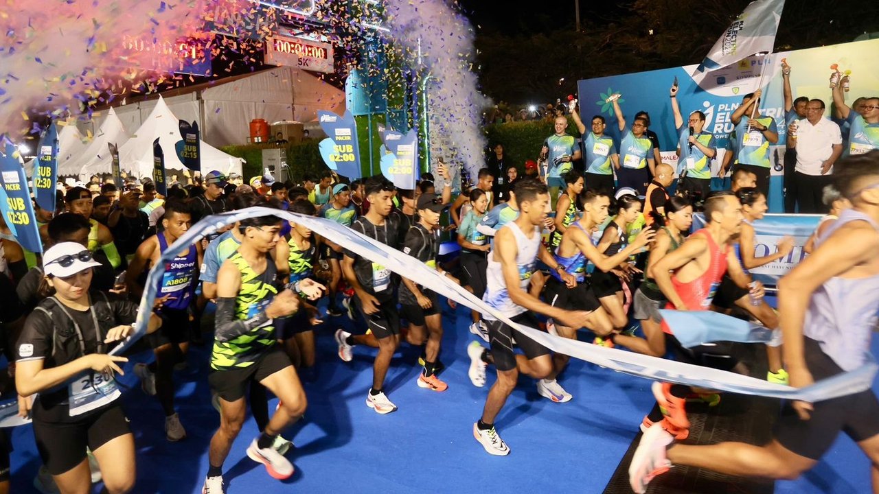 Direktur Utama PLN, Darmawan Prasodjo (kiri) bersama istri, Diny Darmawan Prasodjo (kanan) saat melintasi garis finish dan menyelesaikan PLN Electric Run 2024 kategori 5K