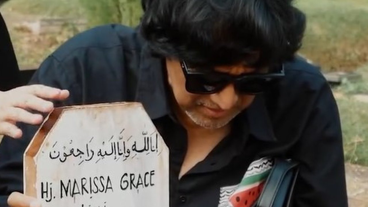 Mengunjungi makam sanga istri setelah berpulang. Ikang Fawzi memakai kacamata hitam untuk menutupi kepedihan yang dirasakan.