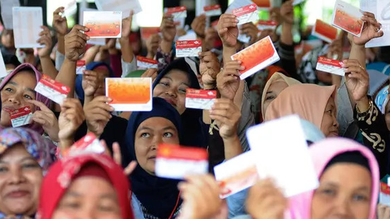 Warga menunjukkan KKS saat Penyaluran Bantuan Sosial PKH dan BPNT di Depok, Jawa Barat, Selasa (12/2).1000 orang warga Depok, Keluarga Penerima Manfaat (KPM) Program Keluarga Harapan (PKH) me
