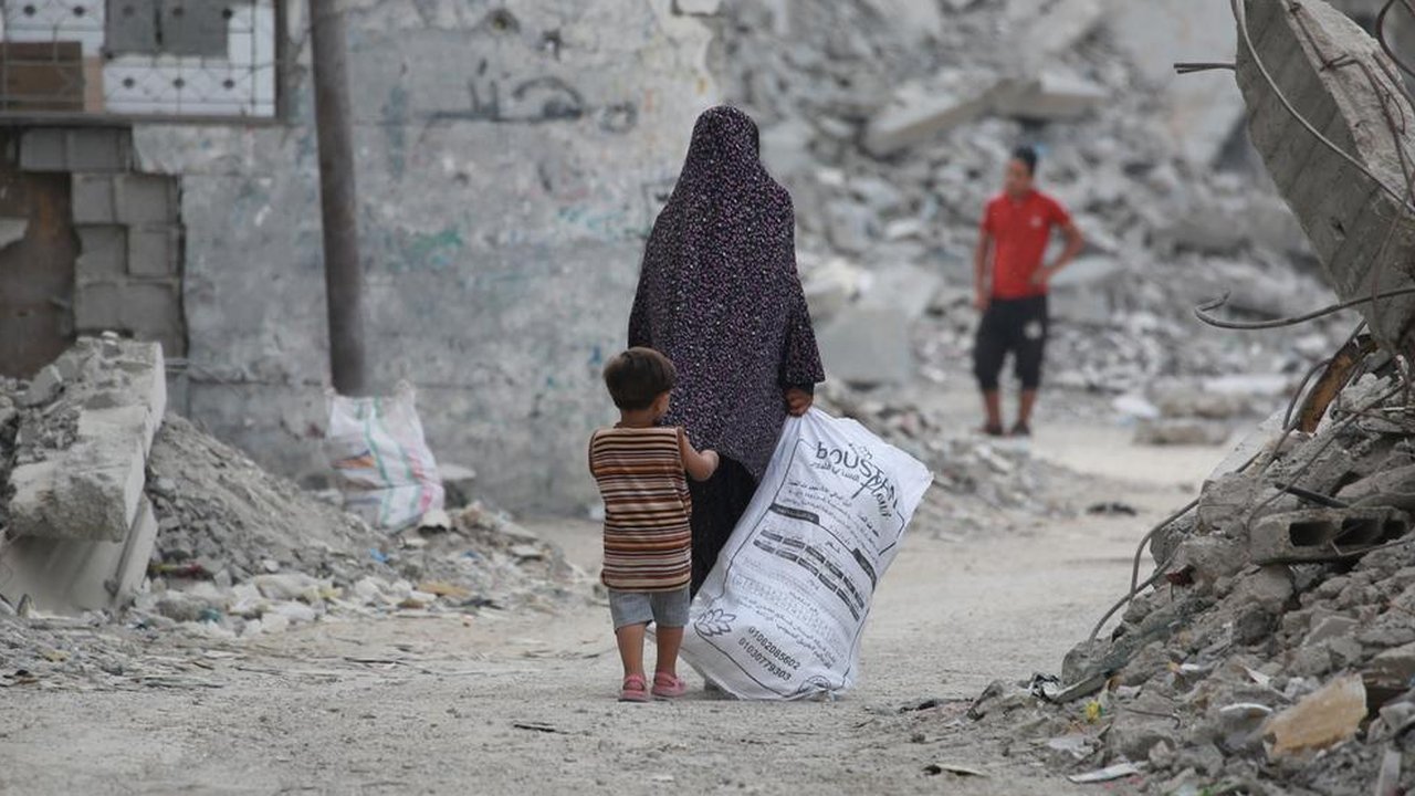 Seorang anak pengungsi Palestina membawa plastik besar untuk diisi dengan barang-barang yang ditemukan di tumpukan sampah, di kamp pengungsi al-Bureij di Jalur Gaza tengah pada 10 November 20