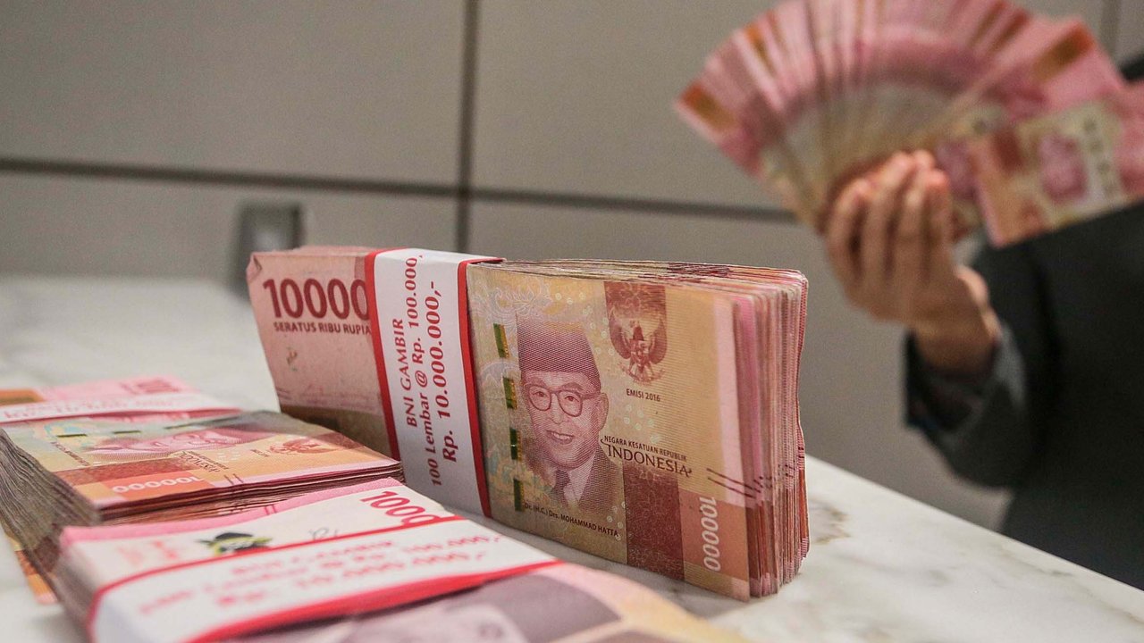 Teller menunjukan mata uang rupiah di Jakarta, Senin (26/2/2024). (Liputan6.com/Angga Yuniar)