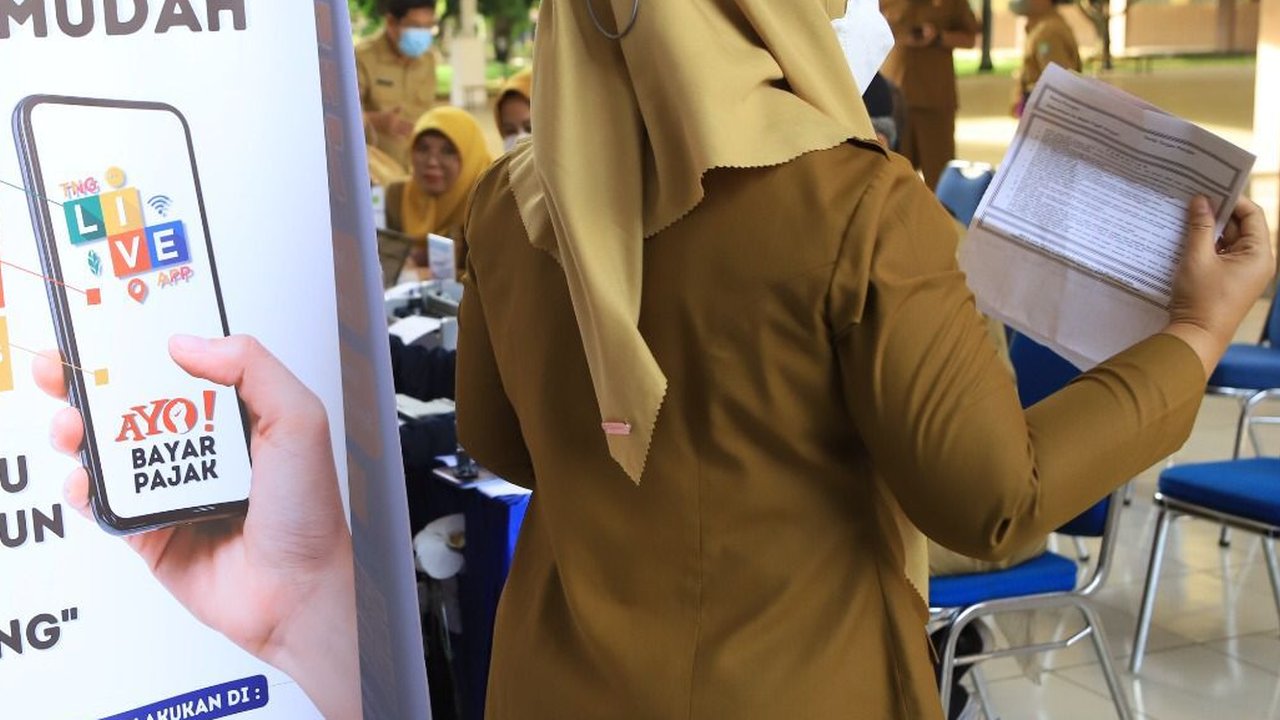 Warga menunjukkan STNK yang baru diperpanjang di gerai Samsat Keliling Car Free Day, Jakarta, Minggu (21/10). Layanan pembayaran pajak Surat Tanda Nomor Kendaraan (STNK) bisa dilakukan tanpa