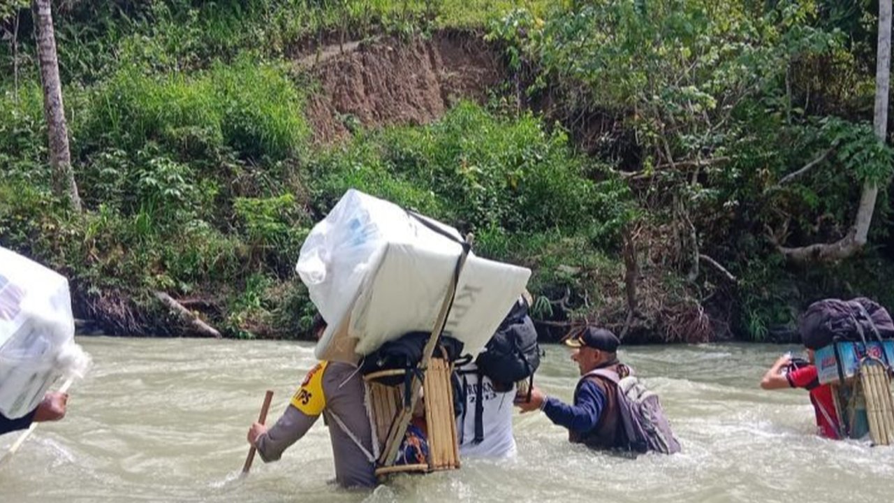 Polisi Jalan Kaki Menerjang Sungai hingga Hutan Belantara Antar Logistik Pilkada