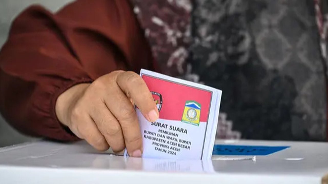Sejak pertama kali diperkenalkan, Pilkada telah menjadi sarana untuk memilih pemimpin daerah yang diharapkan berkualitas. Tampak dalam foto, pemilih memasukkan surat suaranya dalam pemilihan kepala daerah di Darul Imarah, pinggiran Banda Aceh pada 27 November 2024. (CHAIDEER MAHYUDDIN/AFP)