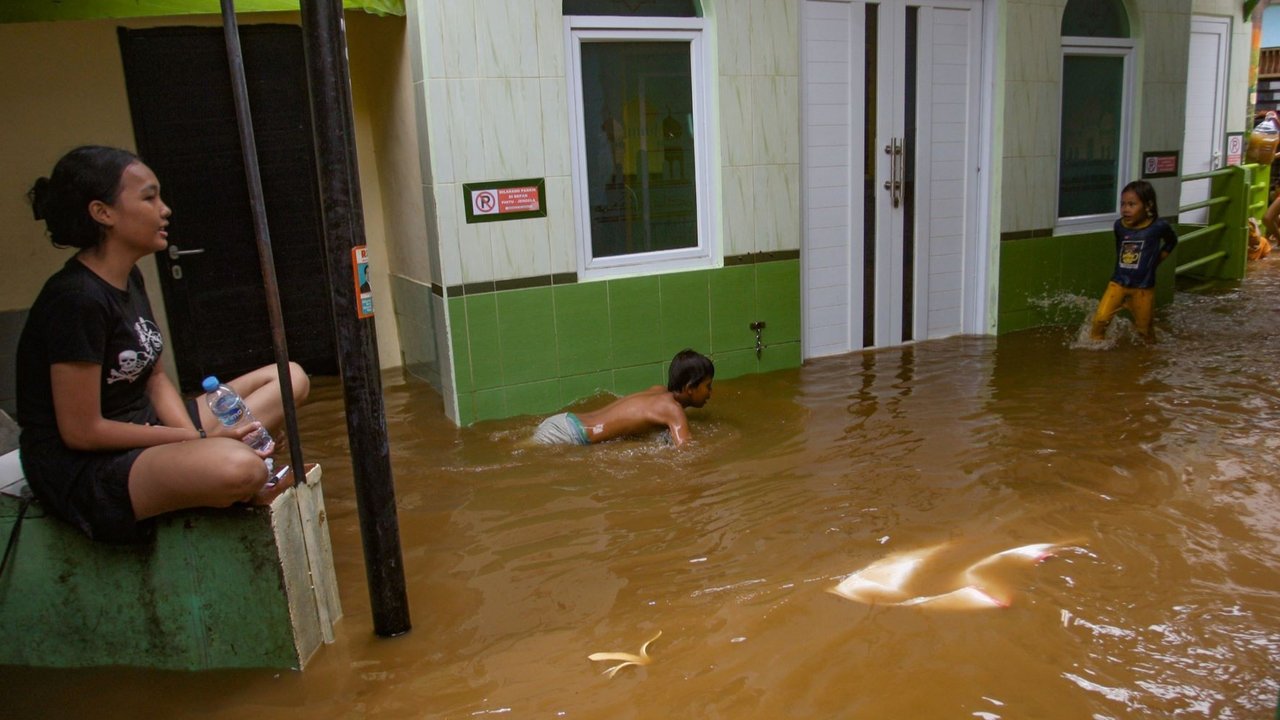 Warga beraktivitas di tengah banjir yang menggenangi pemukiman padat penduduk di Kebon Pala, Kampung Melayu, Jakarta Timur, Kamis (28/11/2024). Banjir akibat meluapnya Sungai Ciliwung itu sempat mencapai ketinggian sekitar 2 meter. Menurut BMKG, fenomena La Nina berdampak pada meningkatnya curah hujan yang lebih tinggi pada awal musim penghujan.