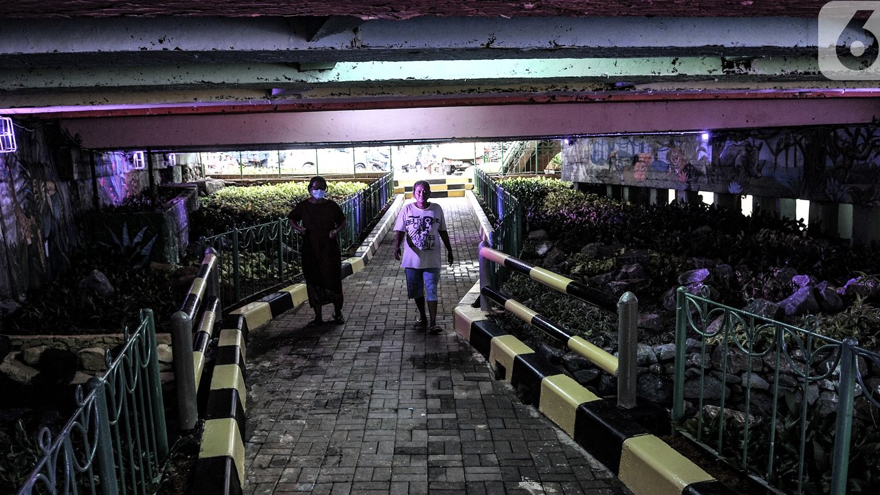 Pejalan kaki melintas di taman kolong Jembatan Pegangsaan, Jakarta, Minggu (7/2/2021). Sebelumnya taman ini merupakan lapak warga tunawisma yang kemudian ditertibkan dan disulap menjadi taman usai Menteri Sosial Risma blusukan pada akhir Desember 2020. (merdeka.com/Iqbal S Nugroho)