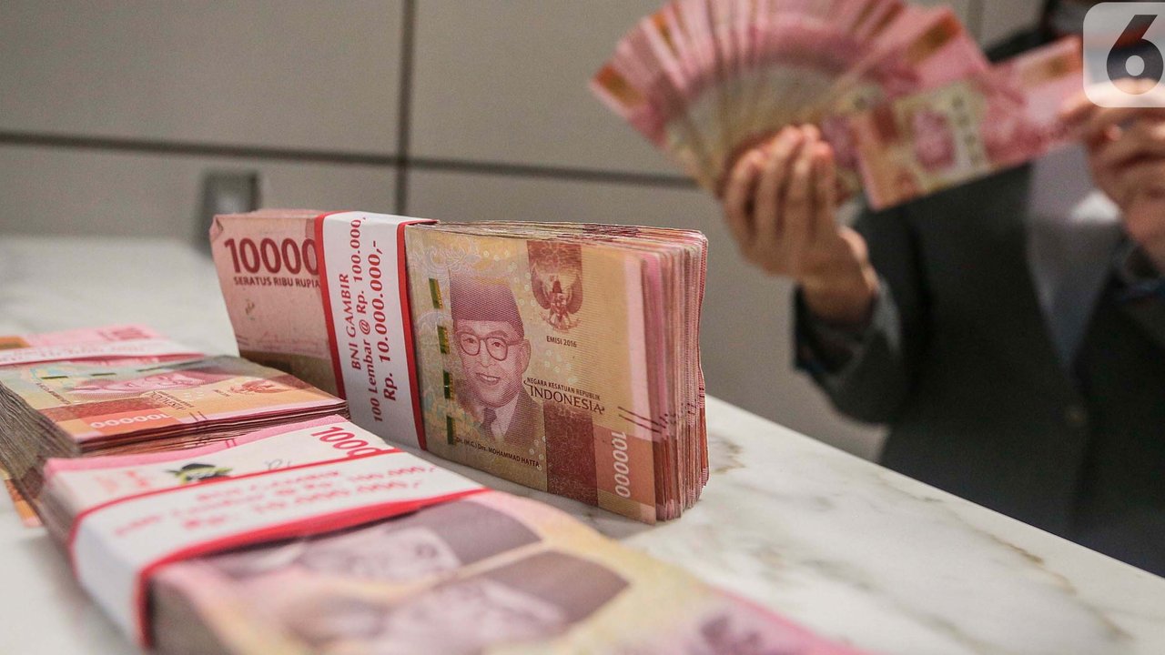 Teller menunjukan mata uang rupiah di Jakarta, Senin (26/2/2024). (Liputan6.com/Angga Yuniar)