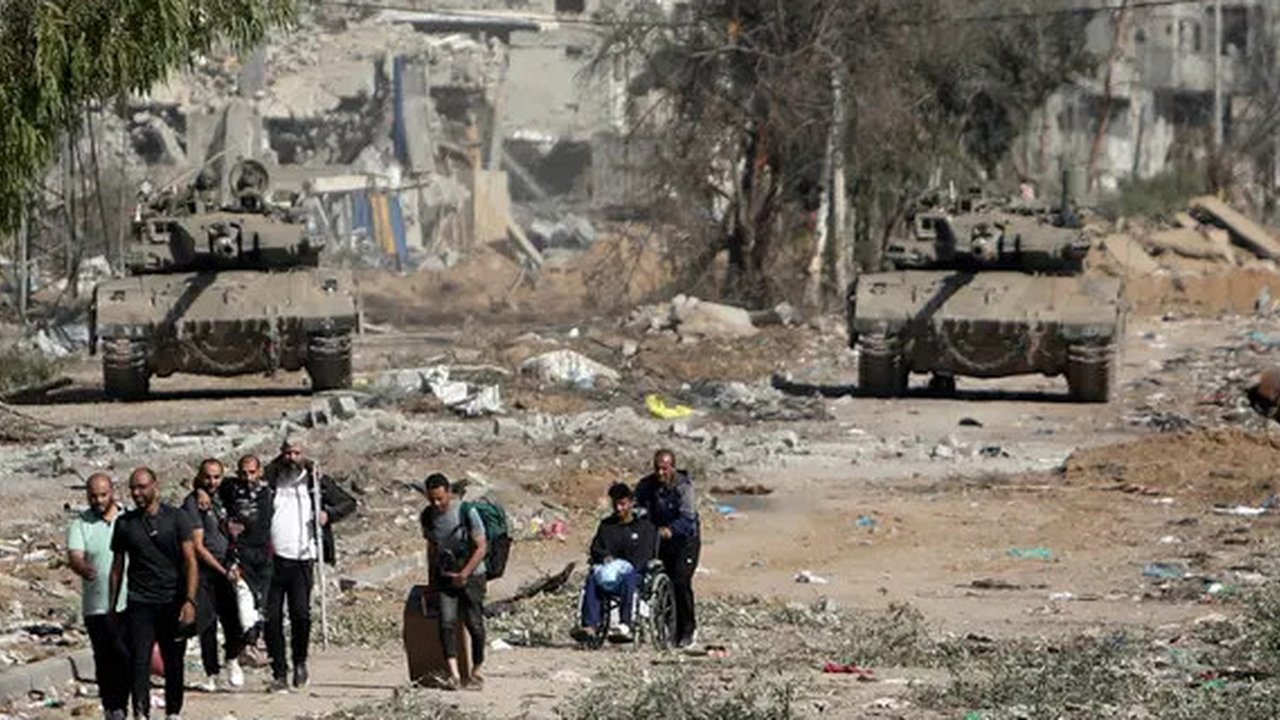 Warga Palestina melarikan diri ke Gaza utara saat tank-tank Israel memblokir jalan Salah al-Din di Jalur Gaza Tengah pada Jumat, 24 November 2023, saat gencatan senjata empat hari dalam peran