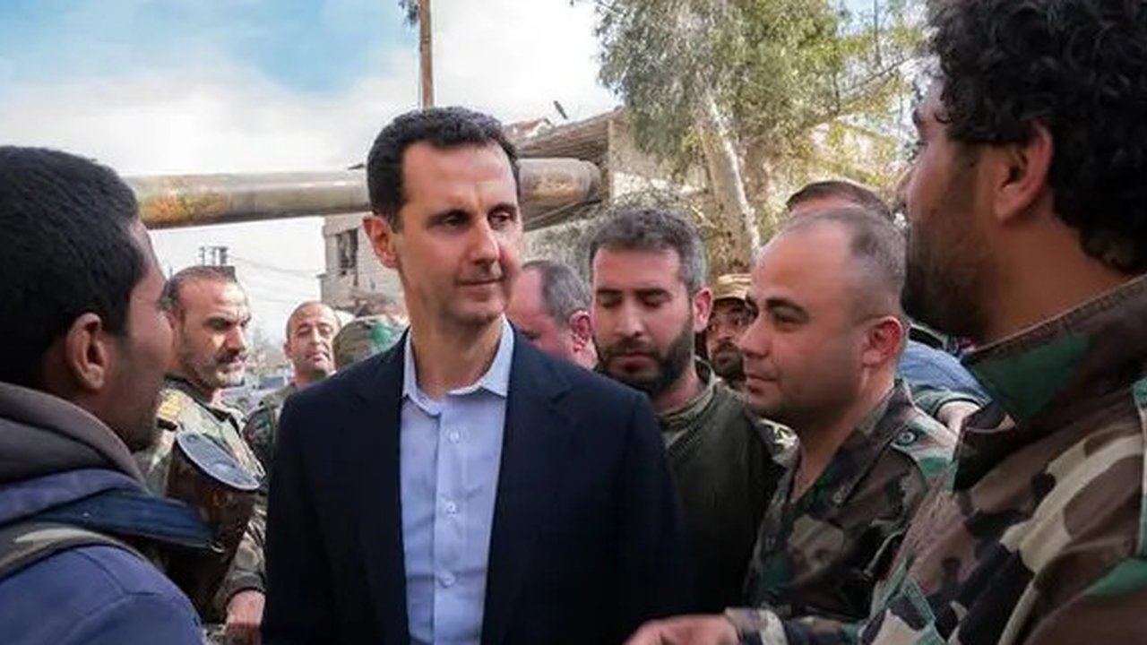 Presiden Suriah Bashar al-Assad berbincang dengan pasukan pemerintah di garis depan wilayah Ghouta Timur, Minggu (18/3). Ini adalah pertama kalinya Assad mengunjungi daerah ini selama bertahu